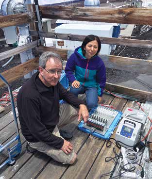 Two scientists sitting next to mercury-measuring instrumentation