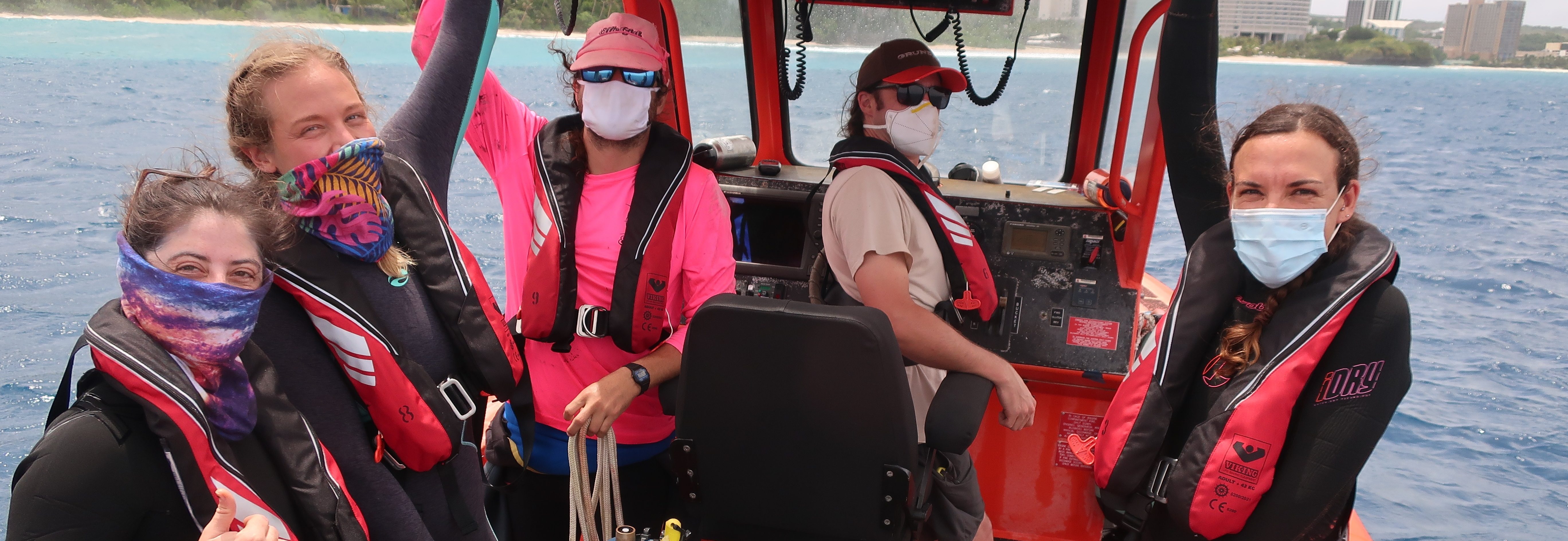 Several scientists on a boat with an instrument