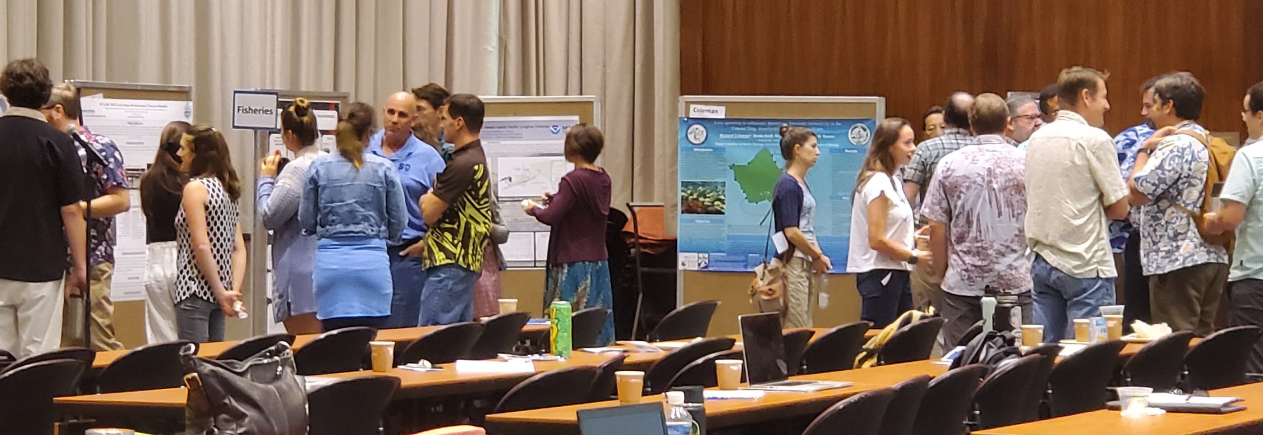 Several scientists gathered around posters at the JIMAR Symposium 2019