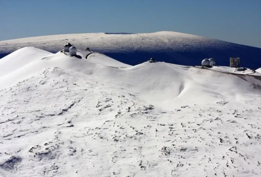 The view from snow-covered Mauna Kea across to a snowy Mauna Loa, Hawaiʻi.