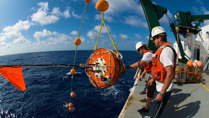 Oceanographers retrieve a sediment trap, above, pulled from the sea at Station ALOHA. The trap captures sinking particles in the ocean. Image courtesy of Paul Lethaby.