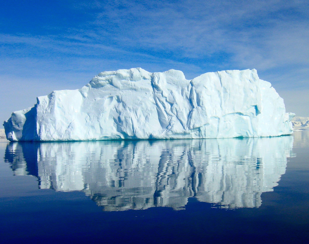 An iceberg floats off the Antarctic Peninsula in calm waters. Credit: Jeffrey Kietzmann, NSF.