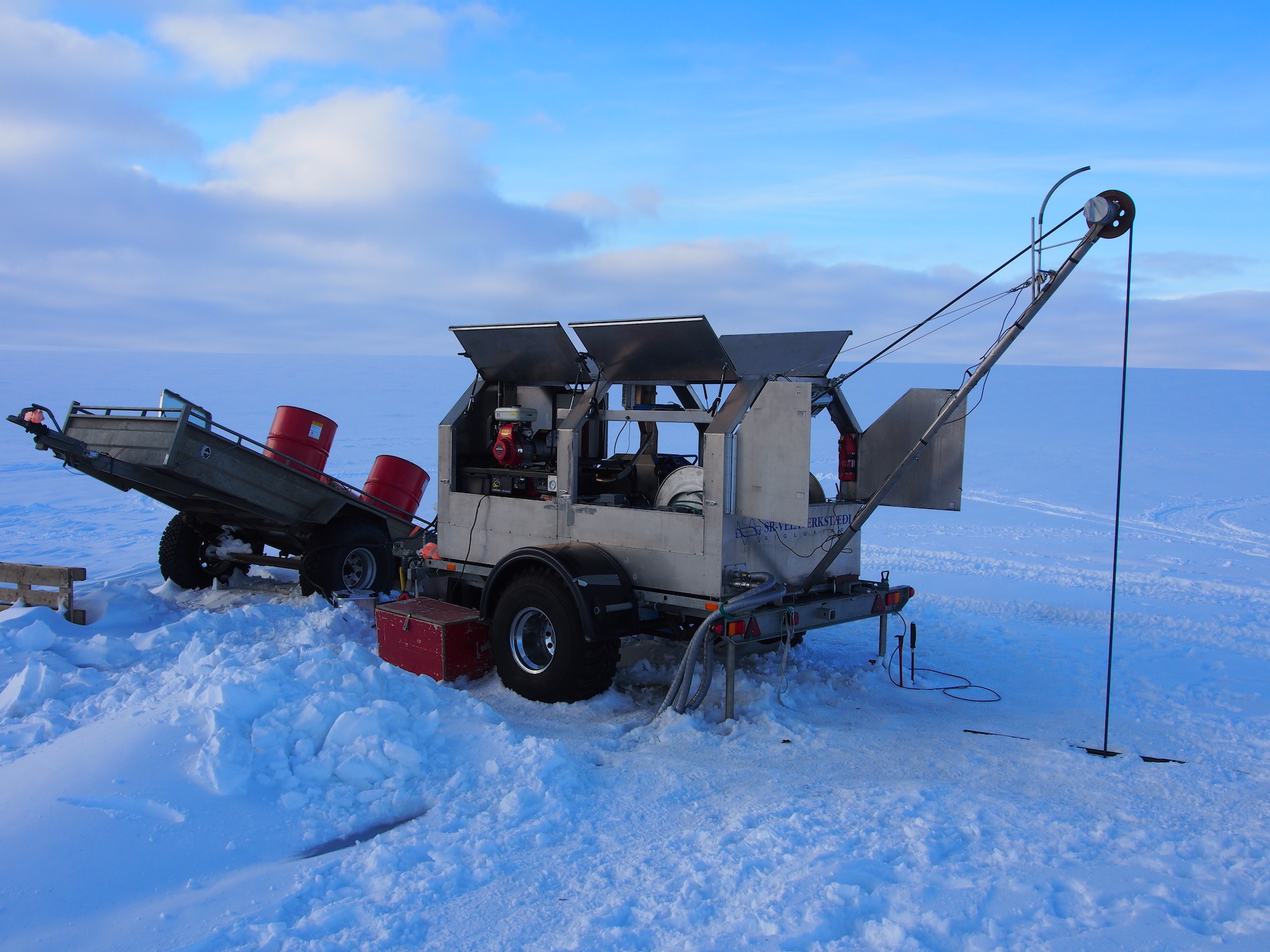 The hot water drill used to drill through the glacier to the subglacial lakes. Open, frozen landscape of the glacier surrounds the drill