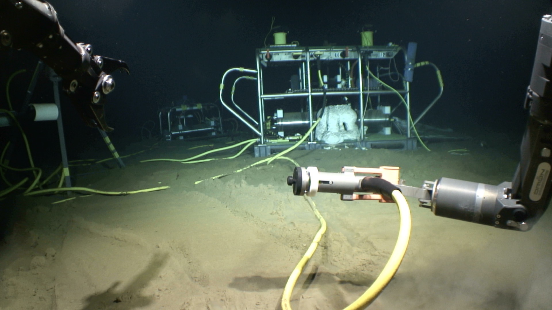 Instrumentation on the seafloor at the Aloha Cabled Observatory with ROV Lu'ukai manipulator arms in view.