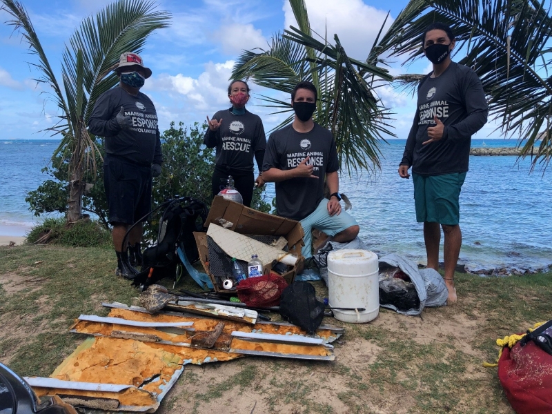 Hawai‘i Marine Animal Response divers on shore with marine debris they collected.