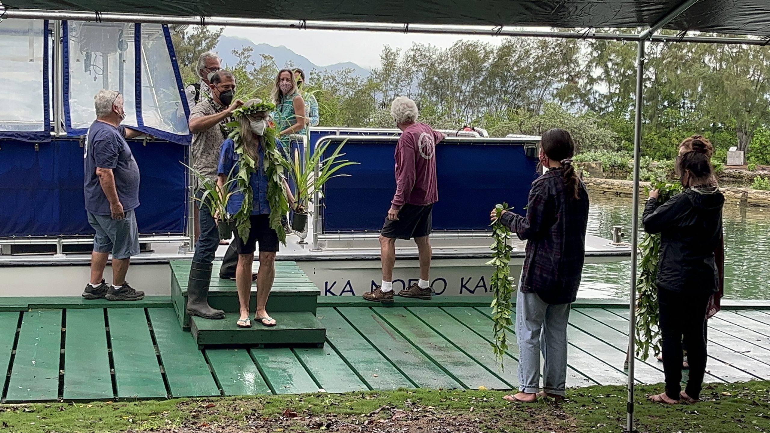 Eleanor Sterling is adorned with lei and presented with ʻiliahi plants native to the island.