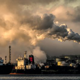 a cloud of emissions flows from a smoke stack
