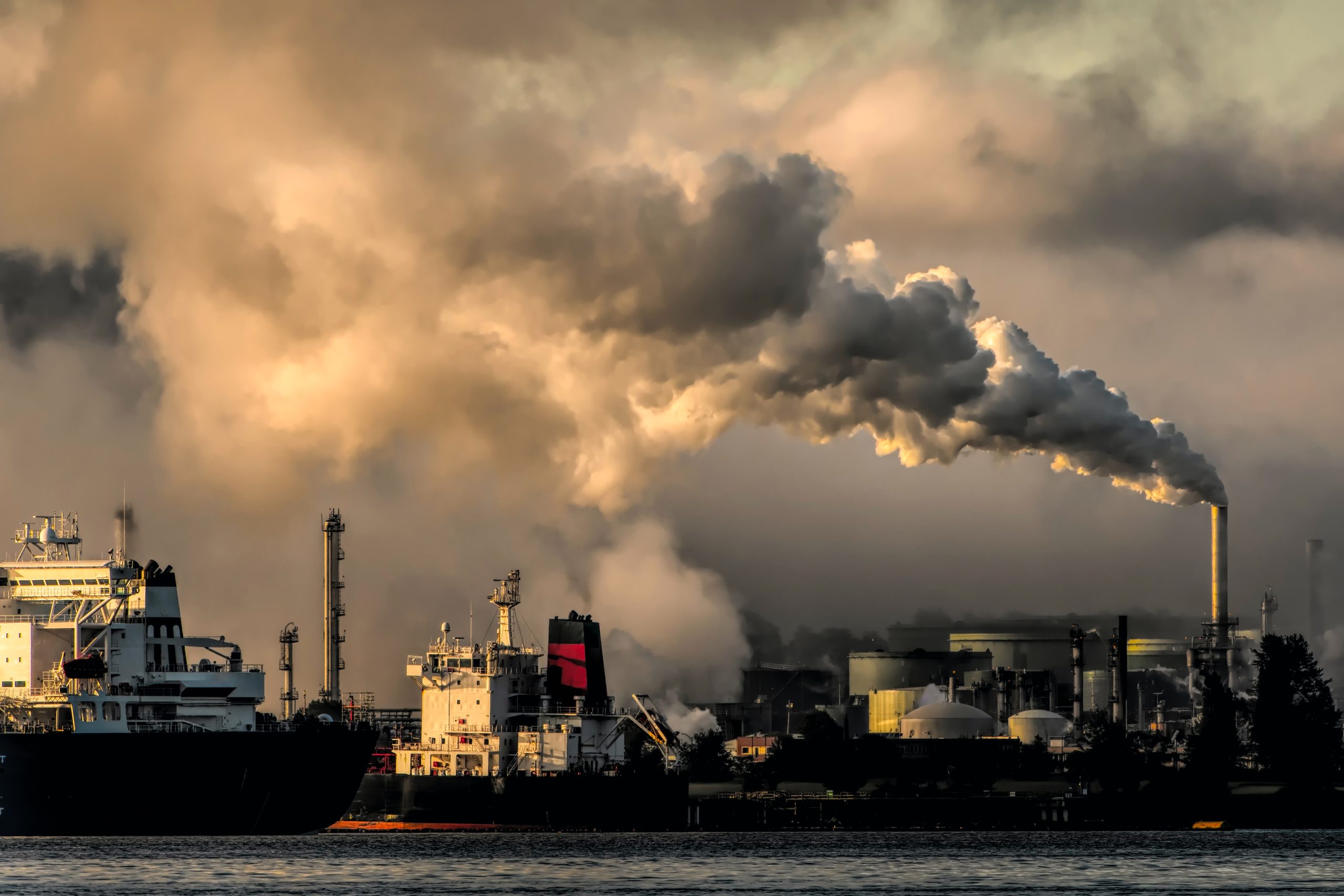 a cloud of emissions flows from a smoke stack