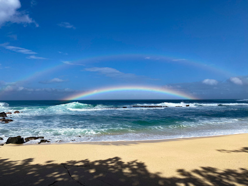 A double rainbow of the Hawaiian shoreline.