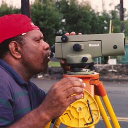 Clement Matupit (Papua New Guinea) prepares to read the NAK-2 leveling gun during a survey for the CSAV International course.