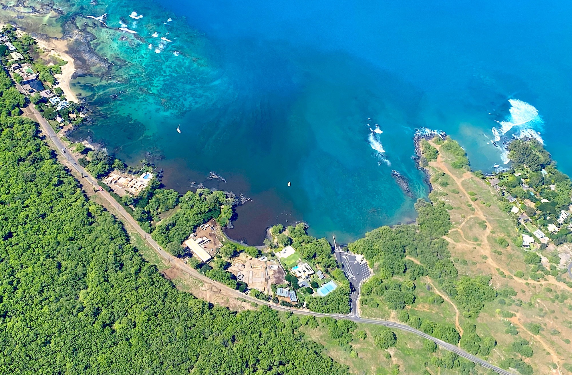 Aerial photograph of Hawaiʻi showing coastal development and land-based impacts adjacent to coral reefs.