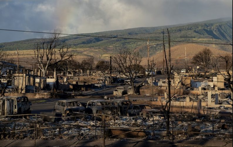 A rainbow is seen from Pu'u Kukui mountain over burned cars and buildings in Lahaina, Hawai‘i, on Aug. 13, 2023.