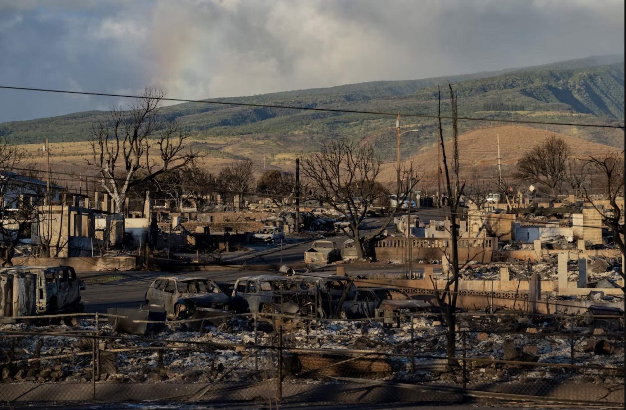 A rainbow is seen from Pu'u Kukui mountain over burned cars and buildings in Lahaina, Hawai‘i, on Aug. 13, 2023.