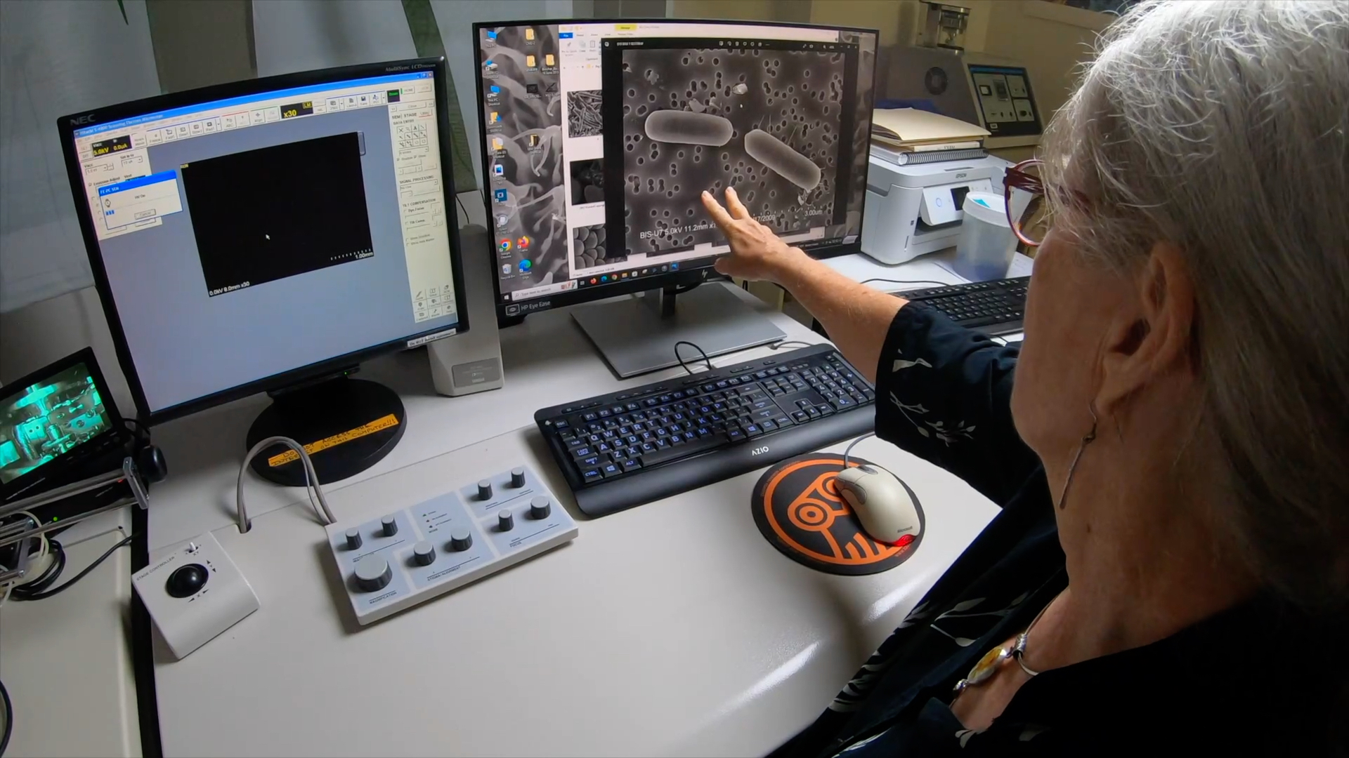 PBRC researcher pointing to microscopy images on computer screen.