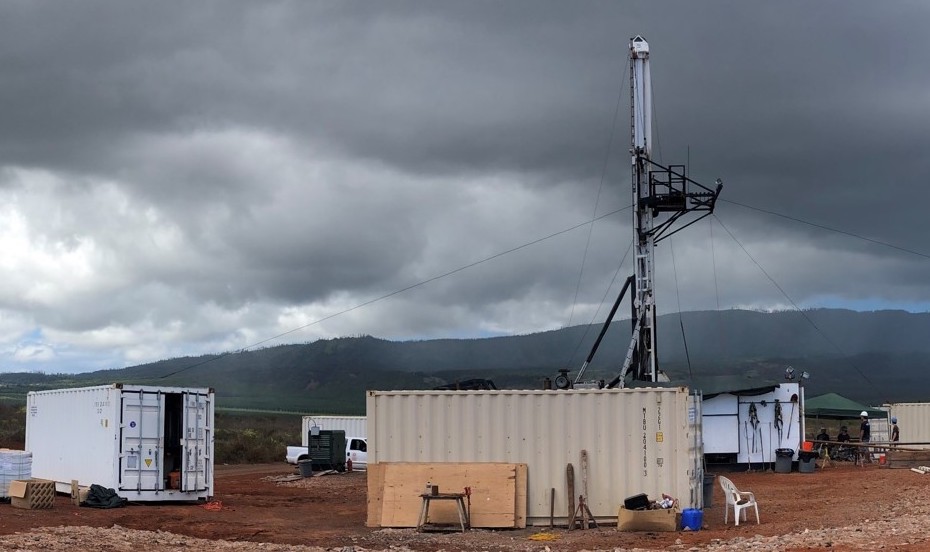Drilling site at a water well in Palawai Basin, Lanai with shipping containers in the foreground, a pop-up tent in the background.