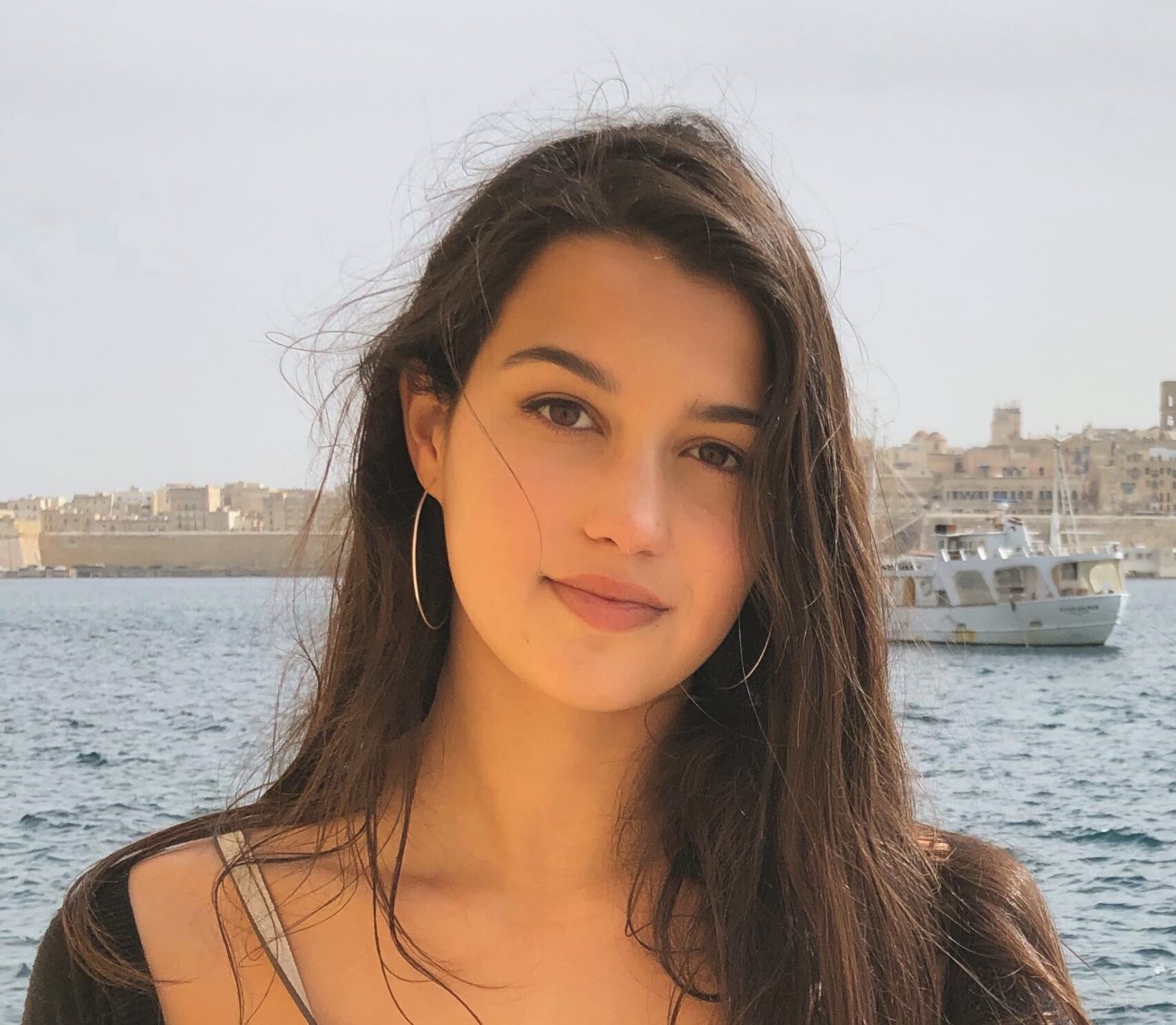 Marley Chertok with a small boat on the water behind her.