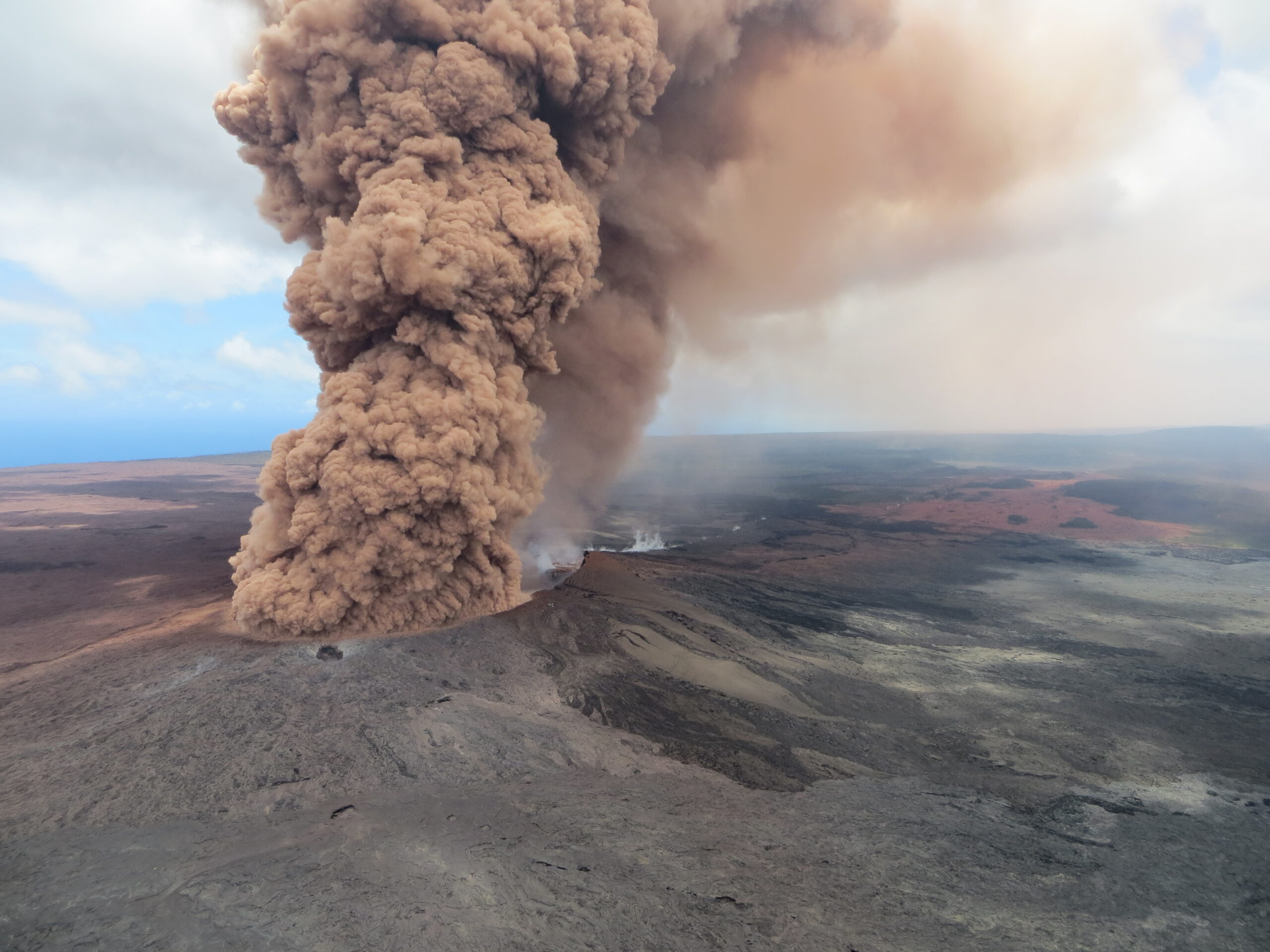 A brown cloud of ash erupted high into the atmosphere from Puʻuʻōʻō in 2018. Credit: USGS.